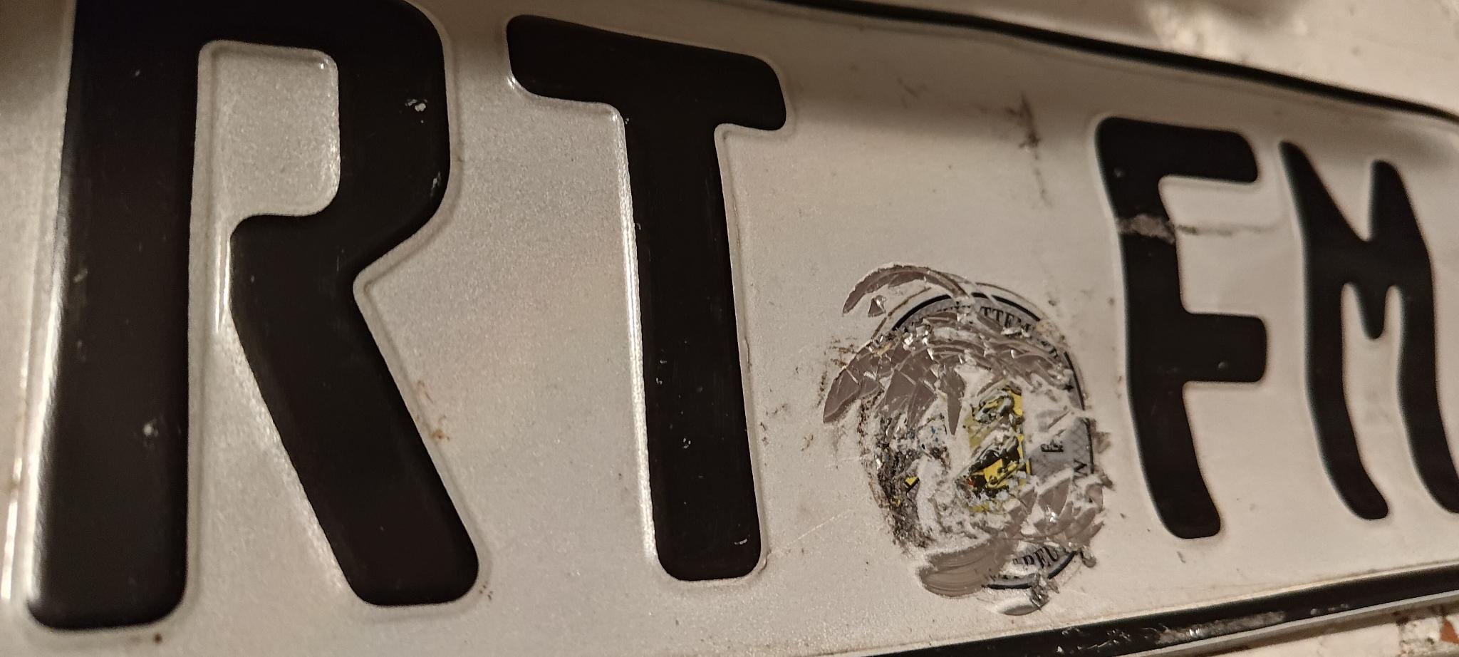 A distorted metal plate reading 'RTFM'